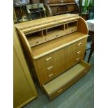 A modern barrel-fronted desk above four long drawers the inside with pigeon holes and drawers. FOR