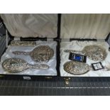 Two reproduction lady's dressing table sets by Broadway & Co., in ornate silver overlay, one of