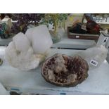 A large fragment of rock crystal geode, a smaller fragment, and a geode containing pink needle-