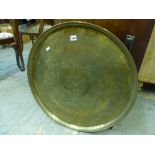 An Eastern circular brass tray-top table on collapsible base. [end of 3rd aisle] FOR DETAILS OF