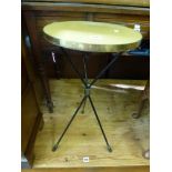 A stylish 1950s occasional table the brass-bound top on three black metal tripod legs. FOR DETAILS