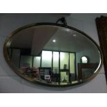 A 1930s circular bevelled metal-framed mirror. FOR DETAILS OF ONLINE BIDDING ON THIS LOT CONTACT