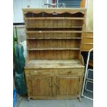 A Victorian stripped pine dresser, the three display shelves above two drawers and two cupboards FOR