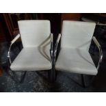 A pair of stylish vintage armchairs in cream leather on chrome frames by Vitra designed by Antonio