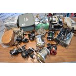 A collection of 12 fishing reels, comprising seven fixed spool reels, four multiplying reels, and