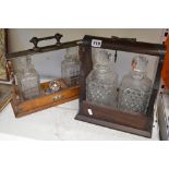 A late Victorian tantalus in oak and EPNS, retaining two decanters and three stoppers, and a