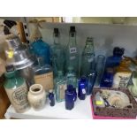 A collection of vintage bottles including blue chemist bottles, R Whites' Gingerbeer, blue soda