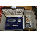 A hallmarked silver manicure set in four pieces in a fitted box, an Edwardian silver-plated purse, a