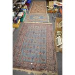 A hand woven rug, the turquoise ground decorated with stylised flowers within a geometric border and