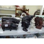 A shelf of African items including two carved wooden hippopotamuses, a carved wooden elephant, three