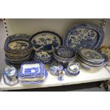 A shelf of blue and white china including willow pattern meat plates, George Jones and Sons Shredded
