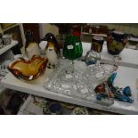 A glass lot comprising a pair of penguin figurines, a dressing table set on tray, an orange fluted