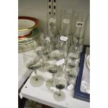 A suite of Orrefors smoky glasses comprising six champagne flutes, six red wine glasses and five