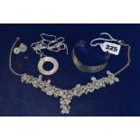 A silver necklace supporting a myriad moonstones, a silver necklace and circular pendant, and a