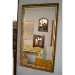 A large rectangular bevel-edged gilt-framed mirror with beaded, leaf and flower decoration TO BID ON