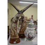 A pair of Eastern buffalo horns, each incised with a dragon and phoenix, on wood stand, together