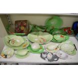 A shelf of cabbage wares plates, bowls, dishes, cruet sets and gravy boats mainly by Carlton Ware [