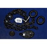 Whitby jet: a carved pendant and a carved brooch, two decorative chains, and two frames TO BID ON