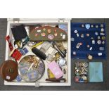 A table display cabinet containing an interesting selection of items including cap badges