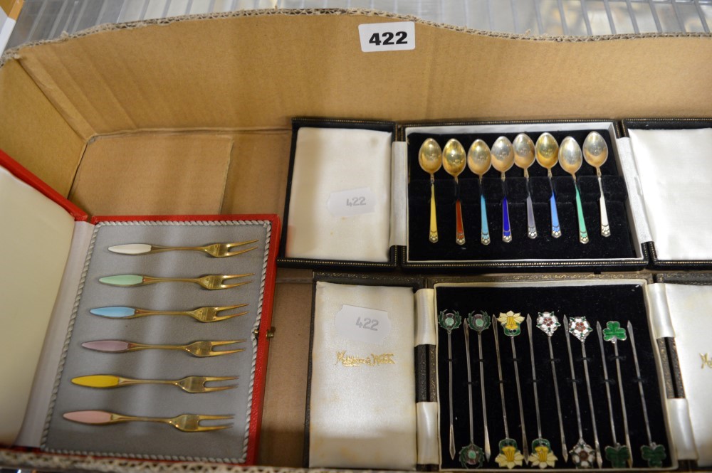 Three cased sets of enamelled implements, comprising: eight silver-gilt and harlequin enamel mocha