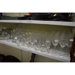 Two shelves of glass ware including sets of wine glasses, lemonade glasses, brandy balloons,