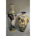 Two modern Moorcroft vases, both with flowers on a pale ground, comprising one with cyclamen,