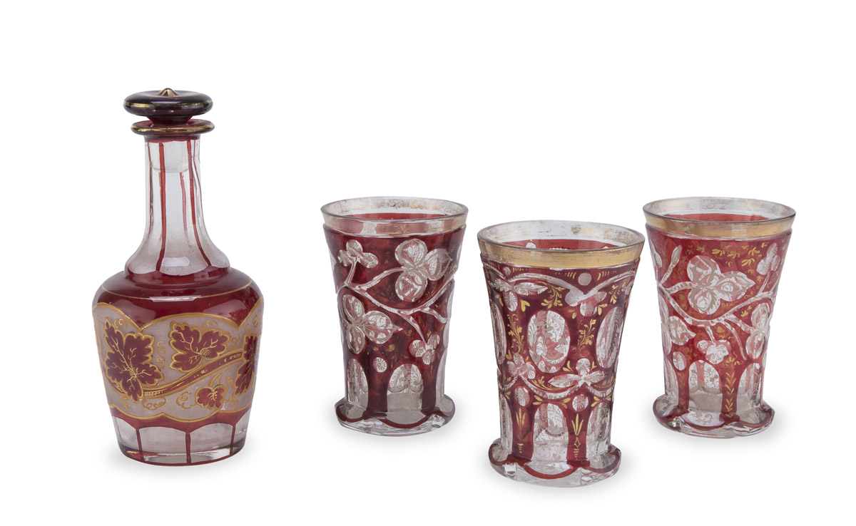 BOTTLE AND THREE GLASSES IN RUBY GLASS AUSTRIA OR BOHEMIA EARLY 20TH CENTURY