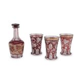 BOTTLE AND THREE GLASSES IN RUBY GLASS AUSTRIA OR BOHEMIA EARLY 20TH CENTURY