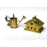 Two 18ct gold charms, one formed as a Swiss chalet, in the style of C. L. Boucher, with hinge
