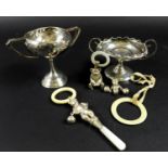A group of silver items comprising two trophies, 7.76toz, and three teething rattles, one in the