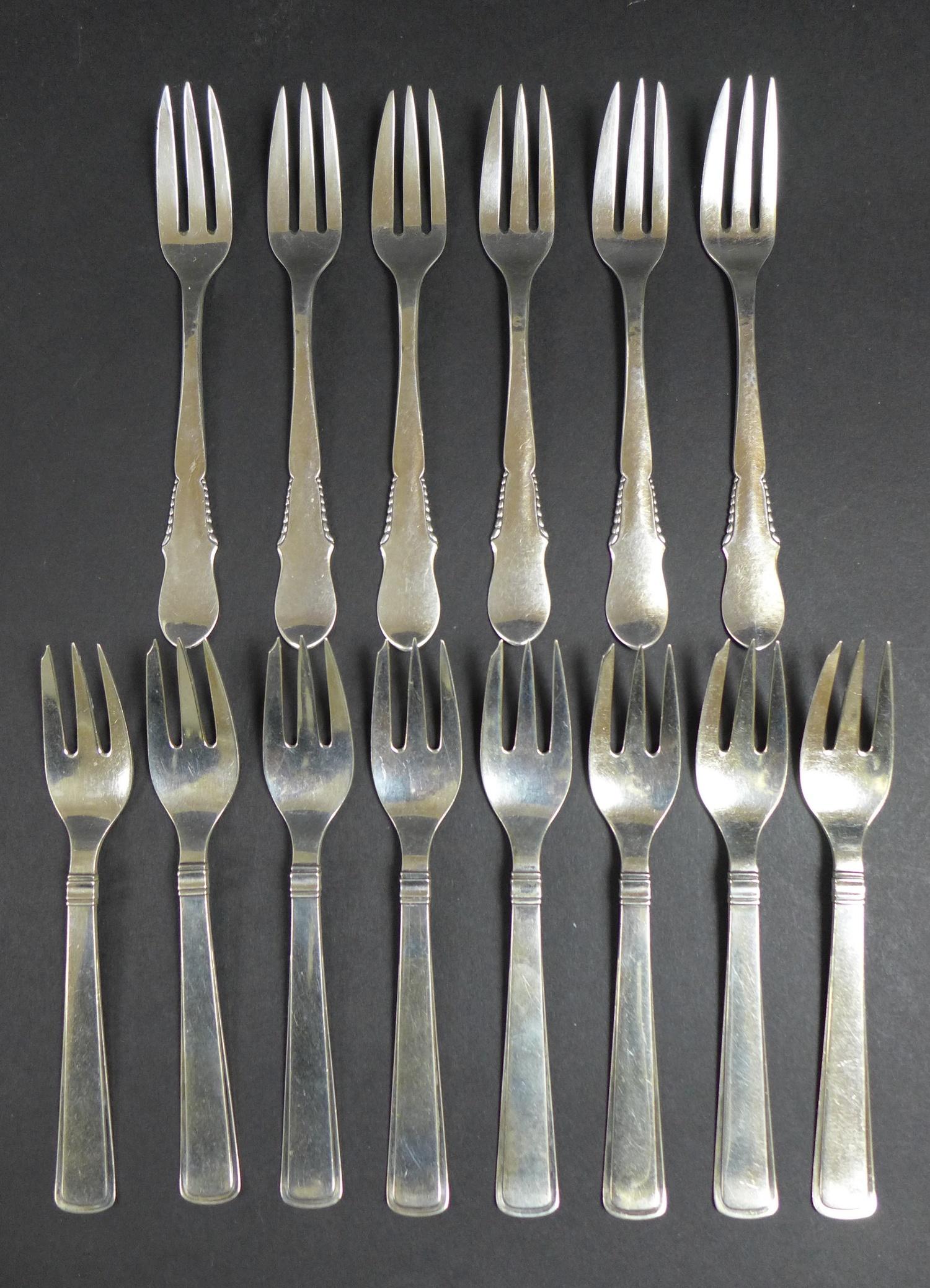 Two sets of Danish silver cake forks, comprising a set of eight by Carl M. Cohr, Johannes