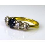 An 18ct gold, sapphire and diamond ring, the sapphire 4 by 4.5mm, flanked by two graduated