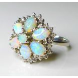 An 18ct white gold and opal dress ring, of flower head form, with six oval opals surrounding a