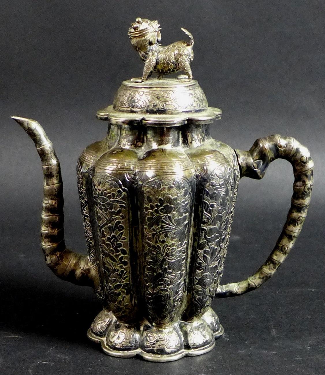 A 19th century Chinese silver wine pot, of lobed tapering form, the cover with shi shi finial,