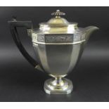 A George V silver teapot, of Neoclassical style, the faceted tapering body with an ebonised finial