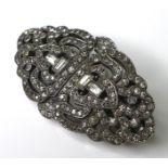 An Art Deco metamorphic brooch, white metal and set with paste, in an open latticework design,