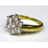An 18ct gold and diamond flowerhead ring, the seven diamonds each of approximately 0.15ct, total