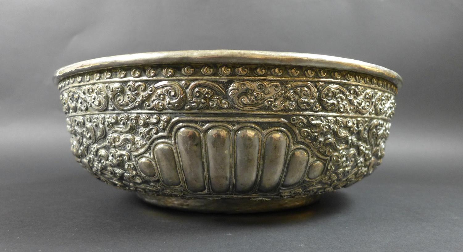 A late 19th century Thai silver large bowl, repousse decorated in relief with three face masks and - Image 4 of 10