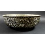 A late 19th century Thai silver large bowl, repousse decorated in relief with three face masks and