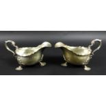A pair of Victorian silver sauce boats, both with shaped handles, and three shell mounted legs, each