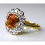 An 18ct gold, diamond and yellow sapphire dress ring, the central honey coloured oval stone of
