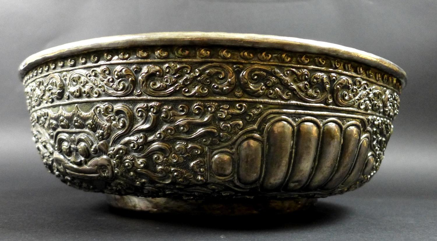 A late 19th century Thai silver large bowl, repousse decorated in relief with three face masks and - Image 3 of 10