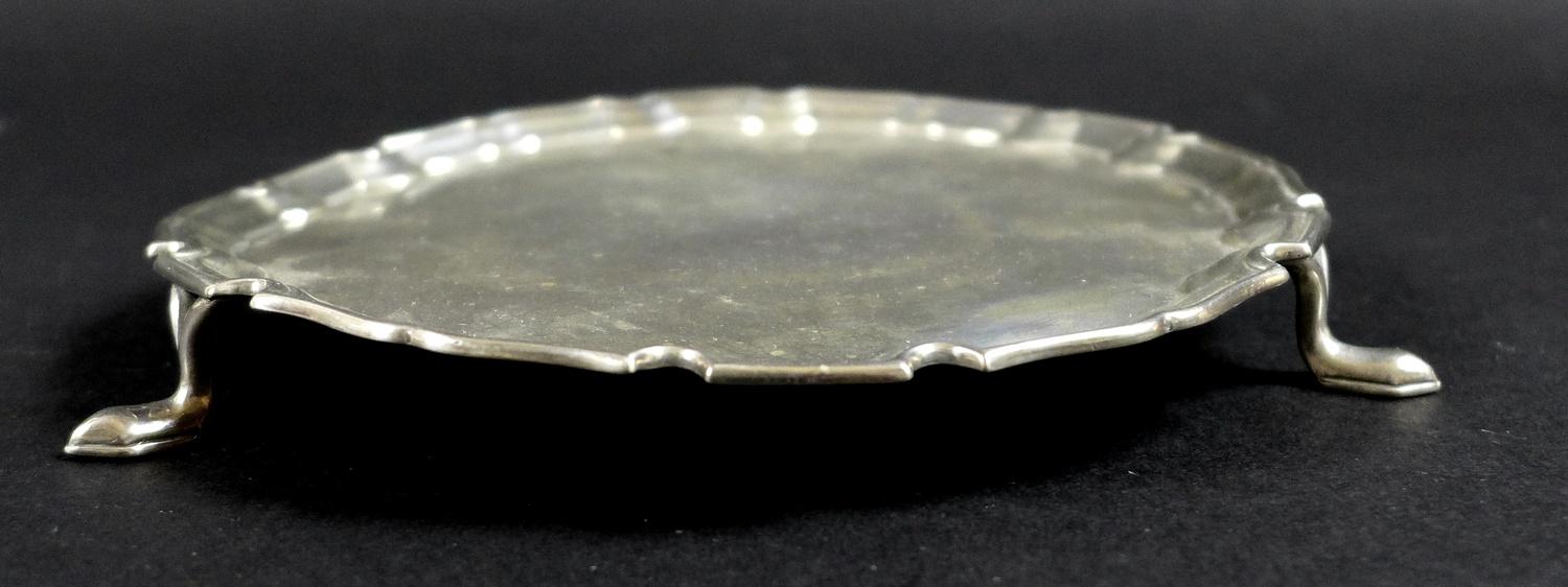 A George V silver waiter tray, of circular form with Chippendale pie crust edge, raised on three - Image 2 of 6