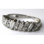 An 18ct white gold and diamond ring, five baguette cut stones, each 4 by 2mm, set alternately with