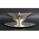 A French silver sauce boat and stand, the sauce boat with scalloped rim, the twin handles and rim