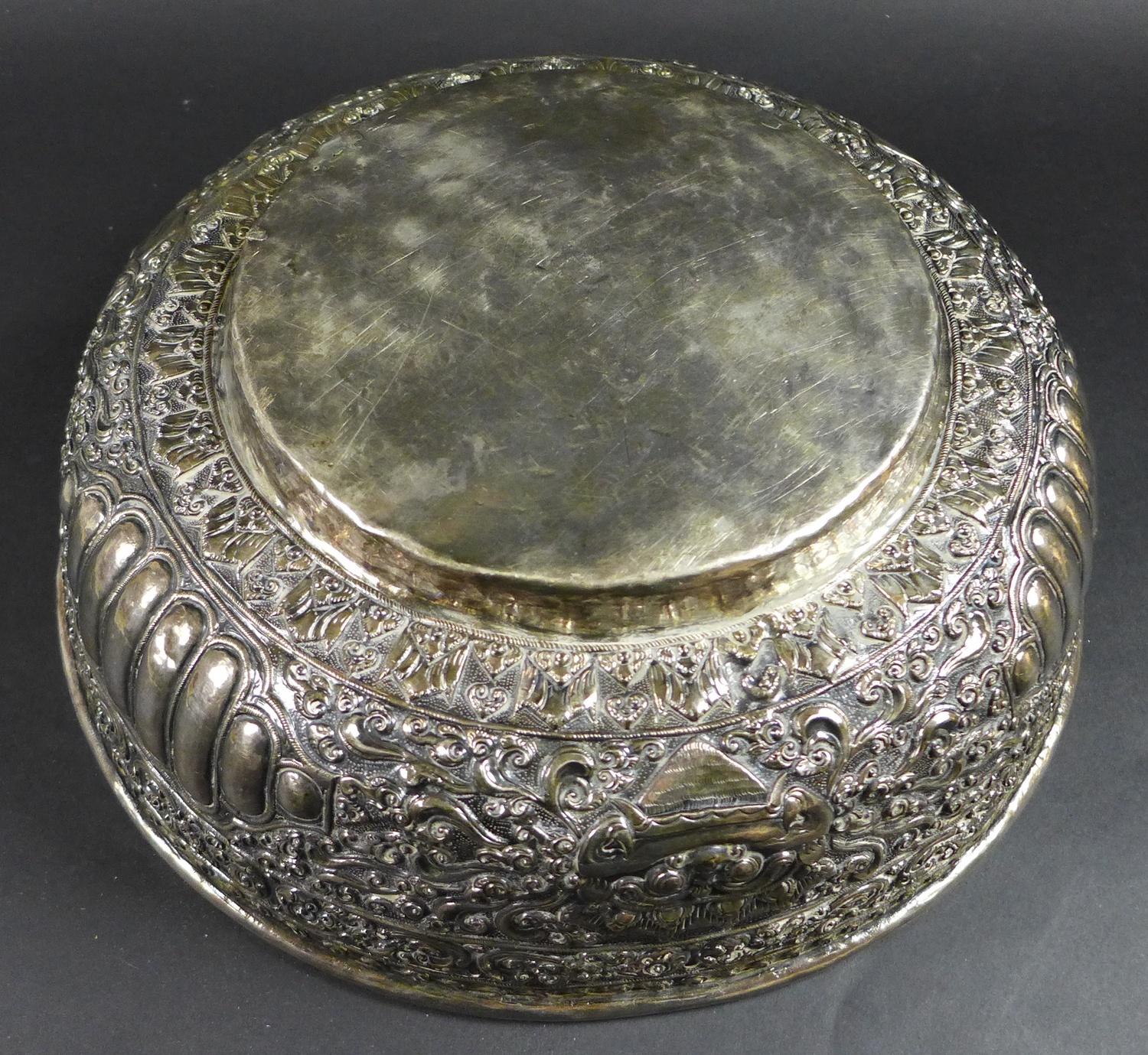 A late 19th century Thai silver large bowl, repousse decorated in relief with three face masks and - Image 8 of 10