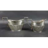 An Edwardian silver sugar bowl 20 by 9.5 by 10.3cm high, and a silver milk jug, 12.6 by 6.4 by 8.9cm