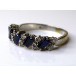 An 18ct white gold, dark sapphire and diamond ring, five baguette cut stones, each 4 by 2mm, set