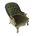 A Victorian spoon back armchair, with green button back upholstery, raised upon mahogany cabriole