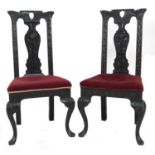 A pair of late 19th century stained oak dining chairs, with poker work carved frames and splat